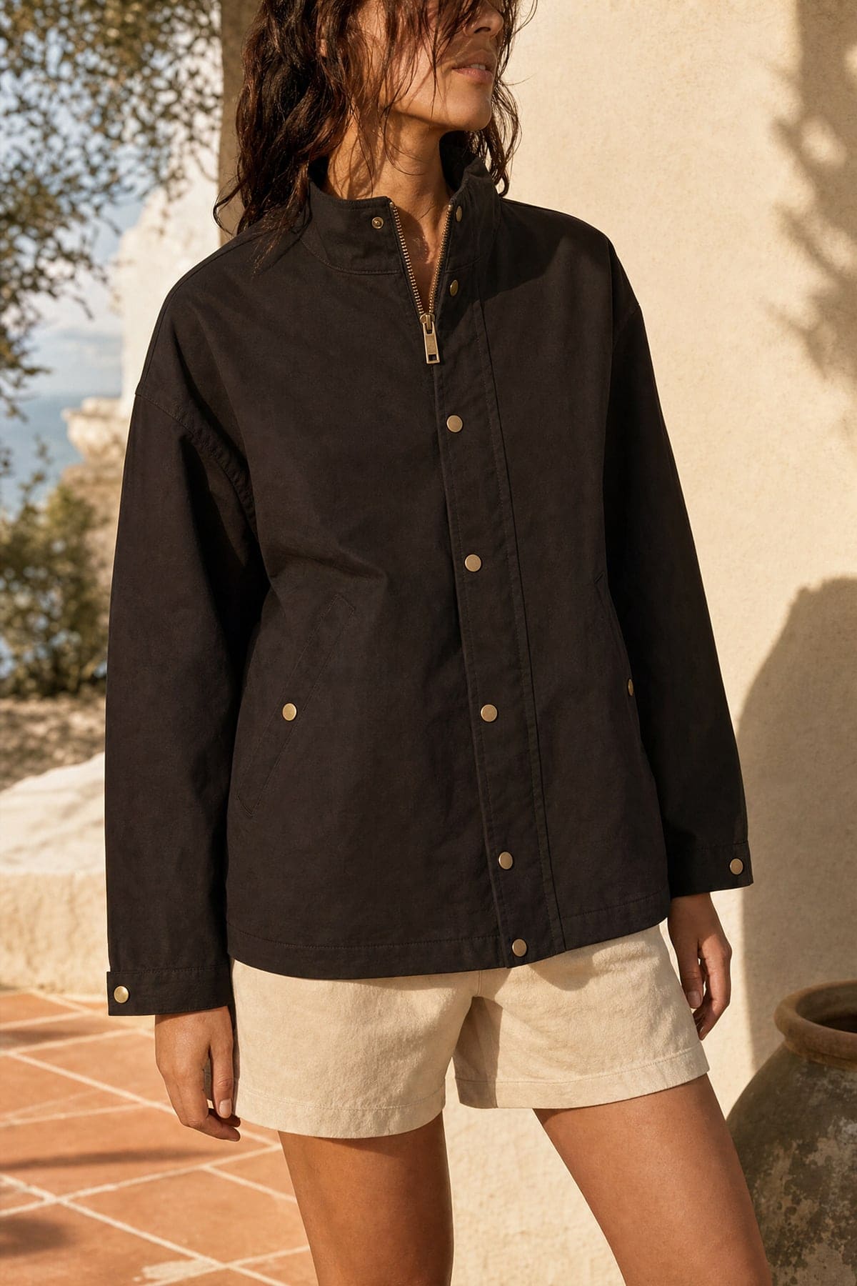 Coach jacket in ink, worn outdoors in warm afternoon light
