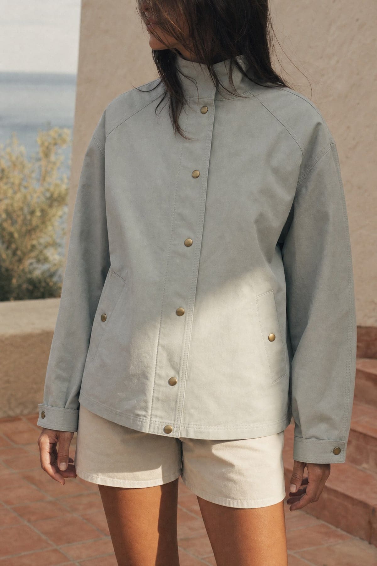 Coach jacket in mist, worn outdoors in warm afternoon light
