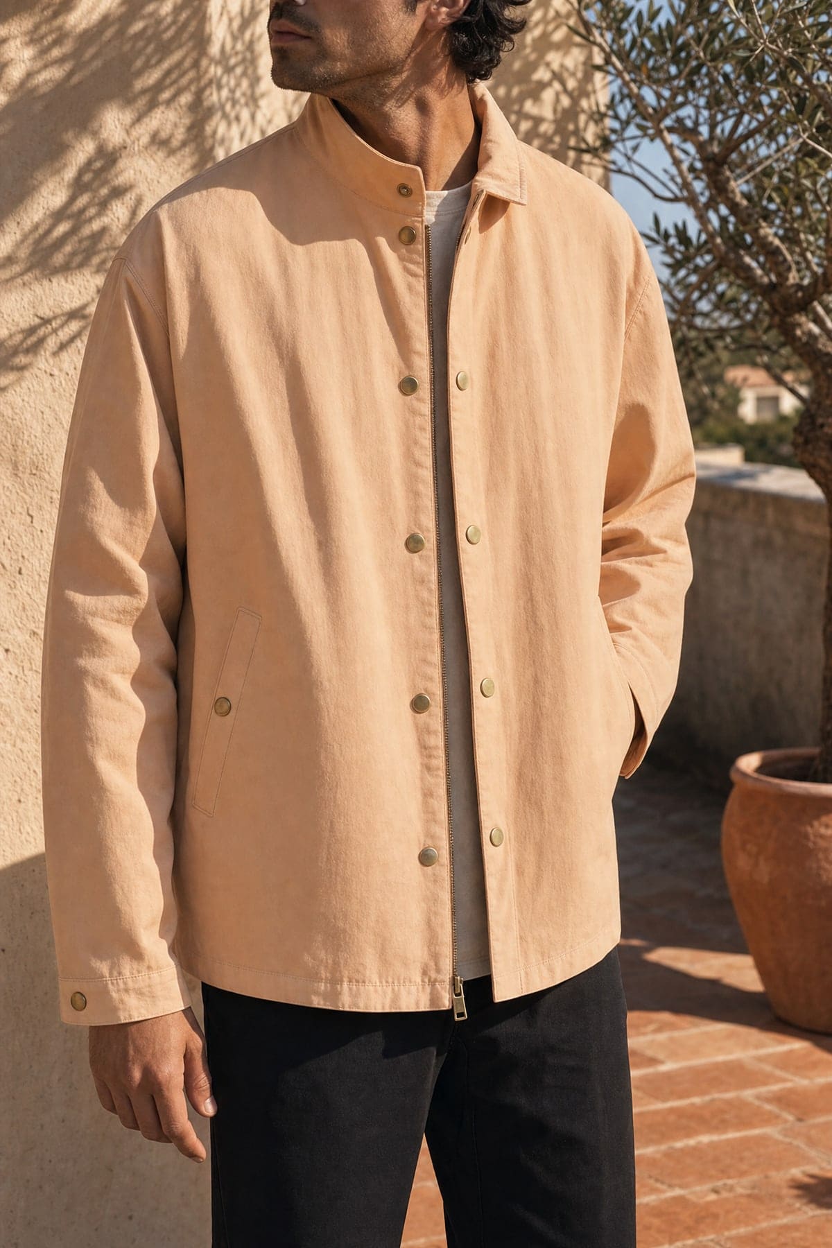 Coach jacket in peach, worn outdoors in warm afternoon light