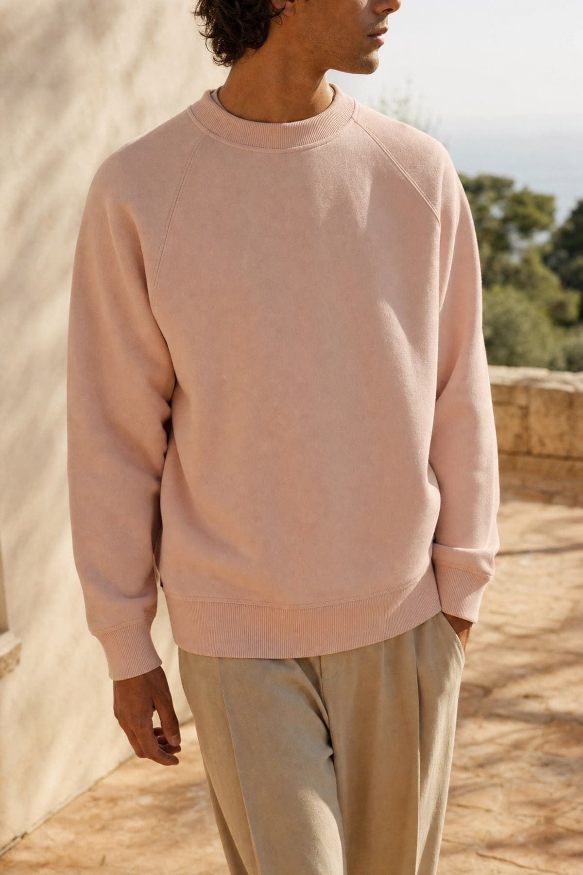 Crewneck in blush, worn outdoors in warm afternoon light