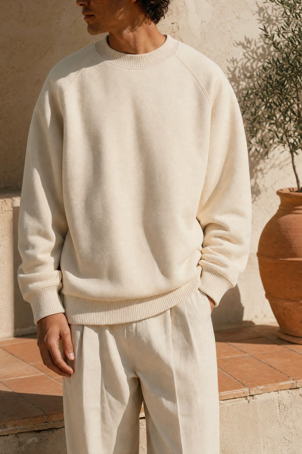 Crewneck in ecru, worn outdoors in warm afternoon light