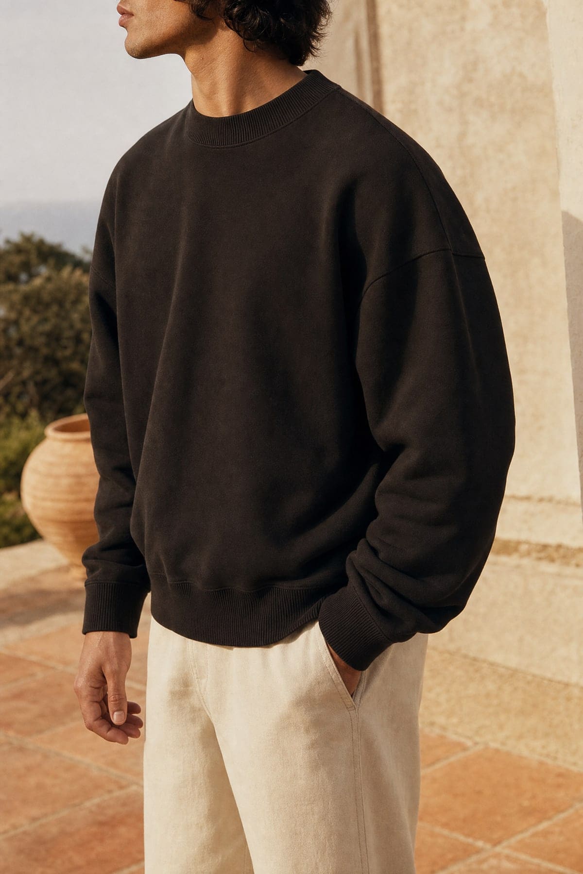 Crewneck in ink, worn outdoors in warm afternoon light
