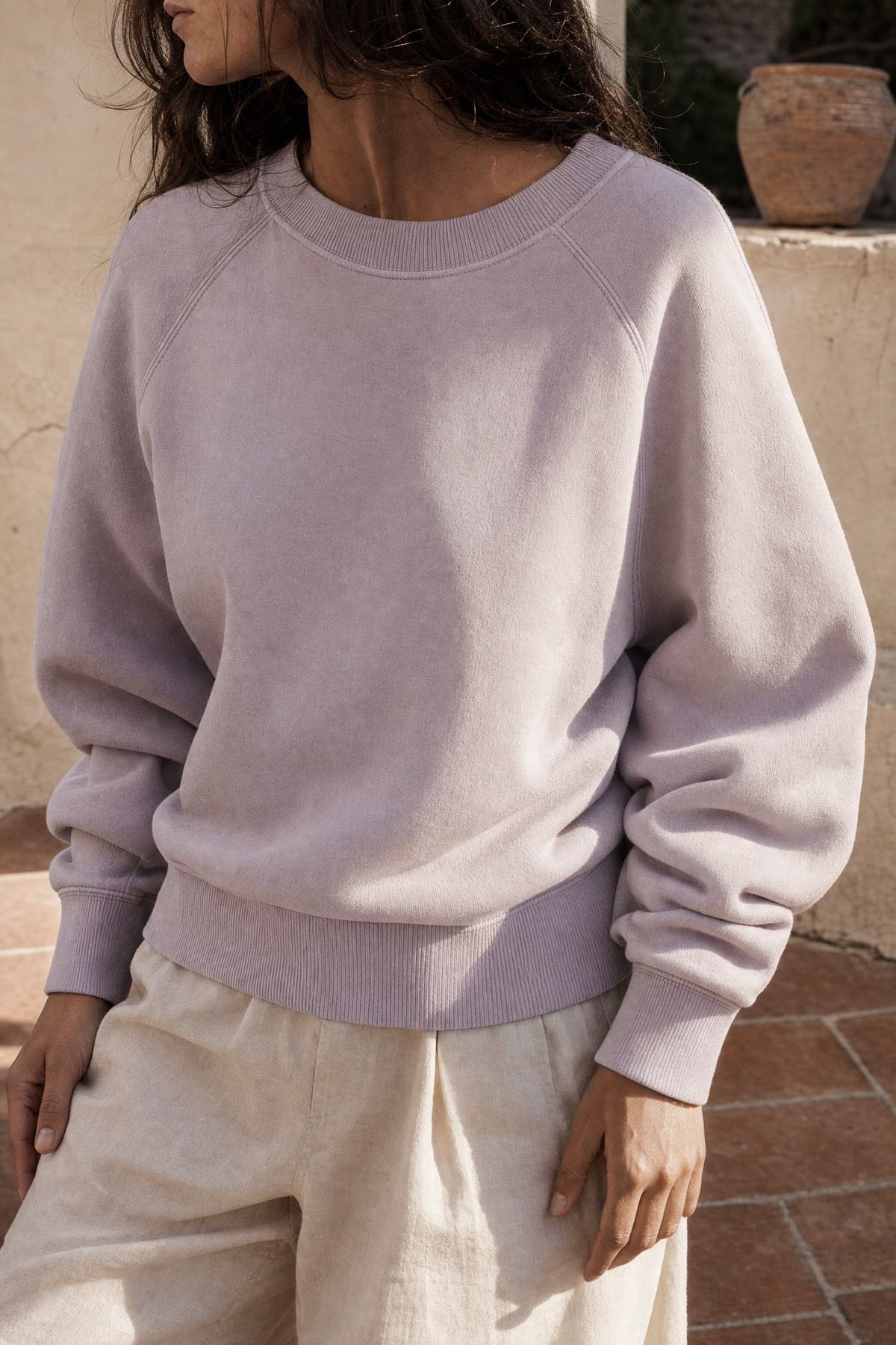 Crewneck in lilac, worn outdoors in warm afternoon light