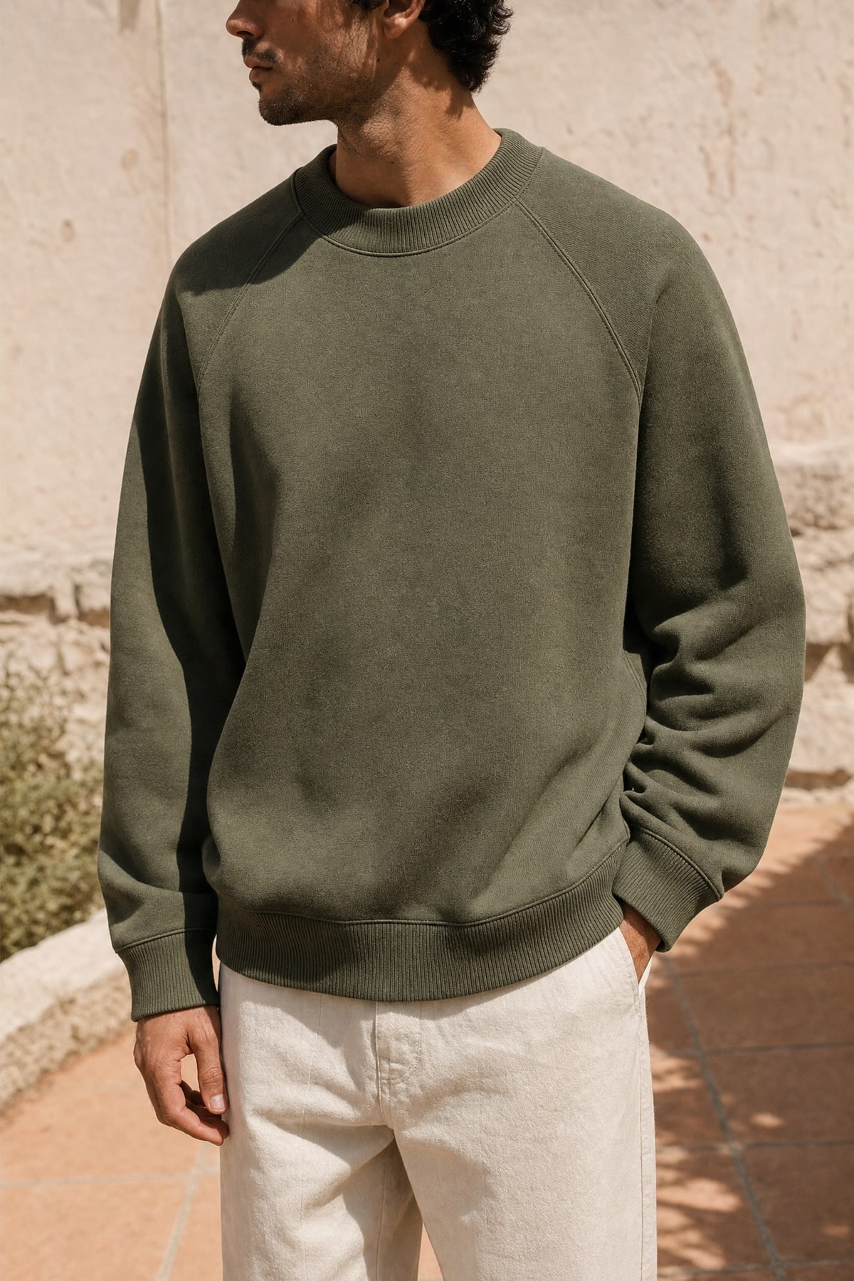 Crewneck in olive, worn outdoors in warm afternoon light
