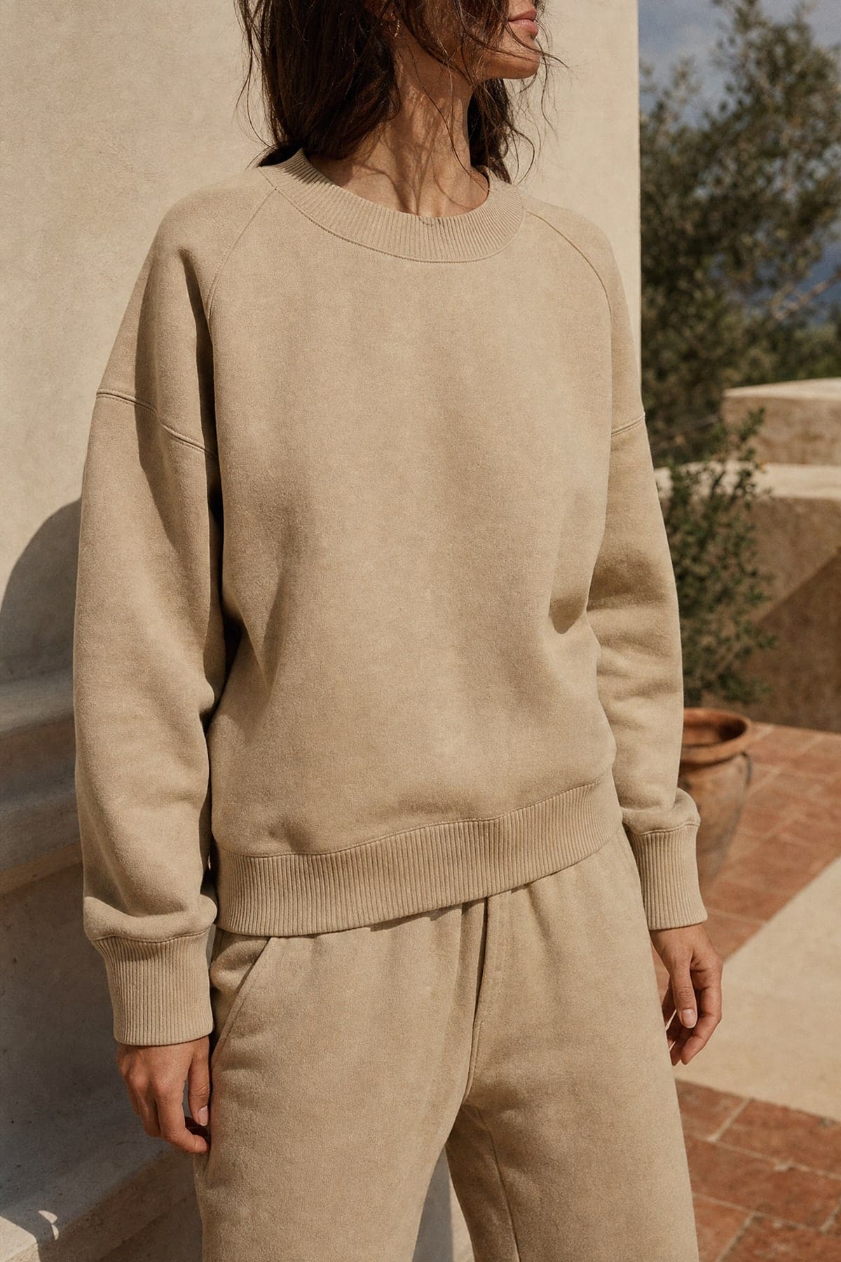Crewneck in stone, worn outdoors in warm afternoon light
