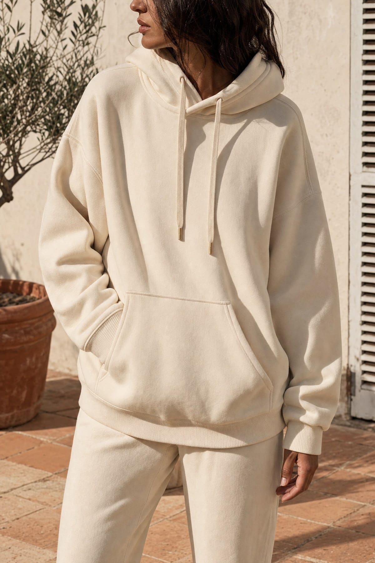 Hoodie in ecru, worn outdoors in warm afternoon light