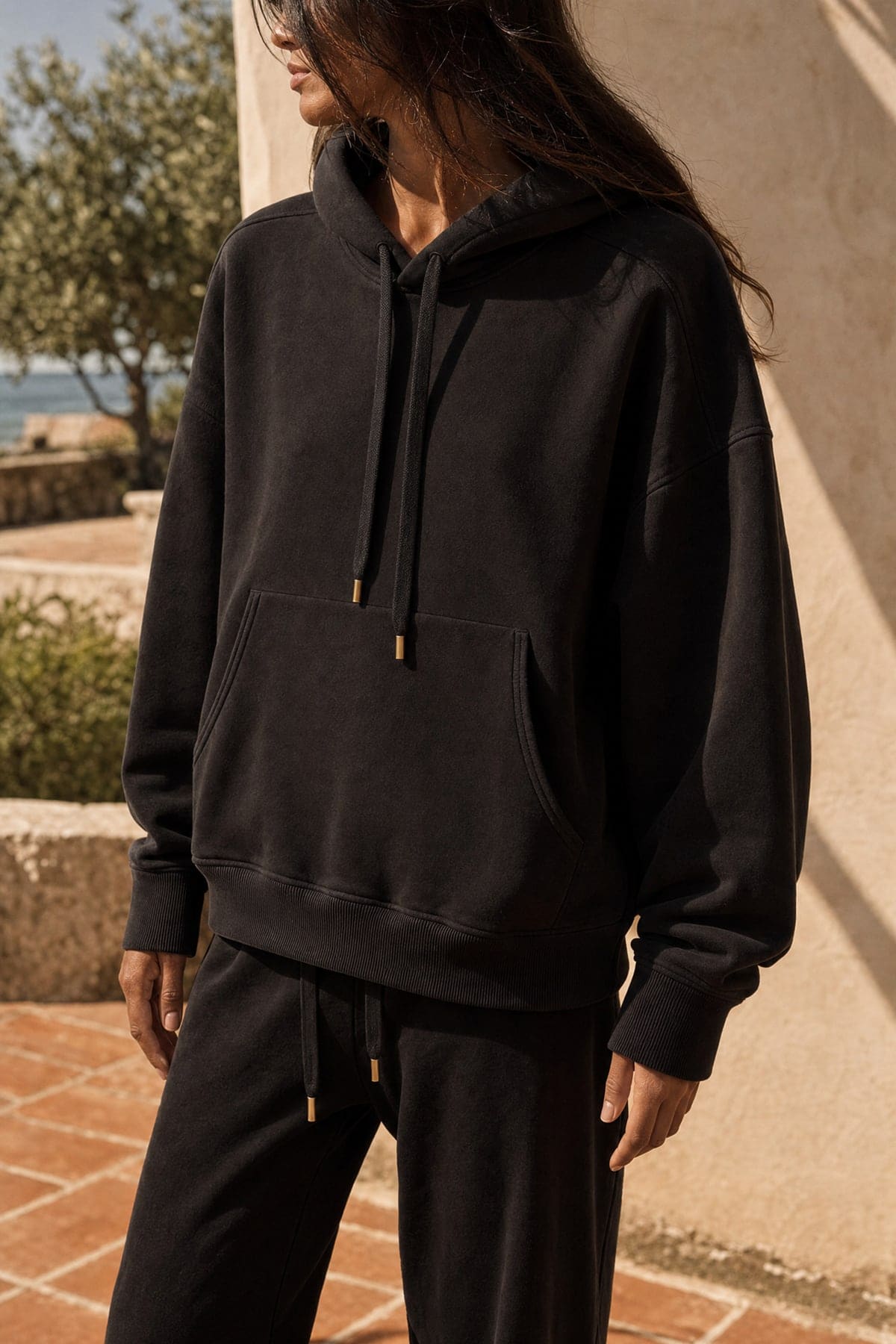 Hoodie in ink, worn outdoors in warm afternoon light