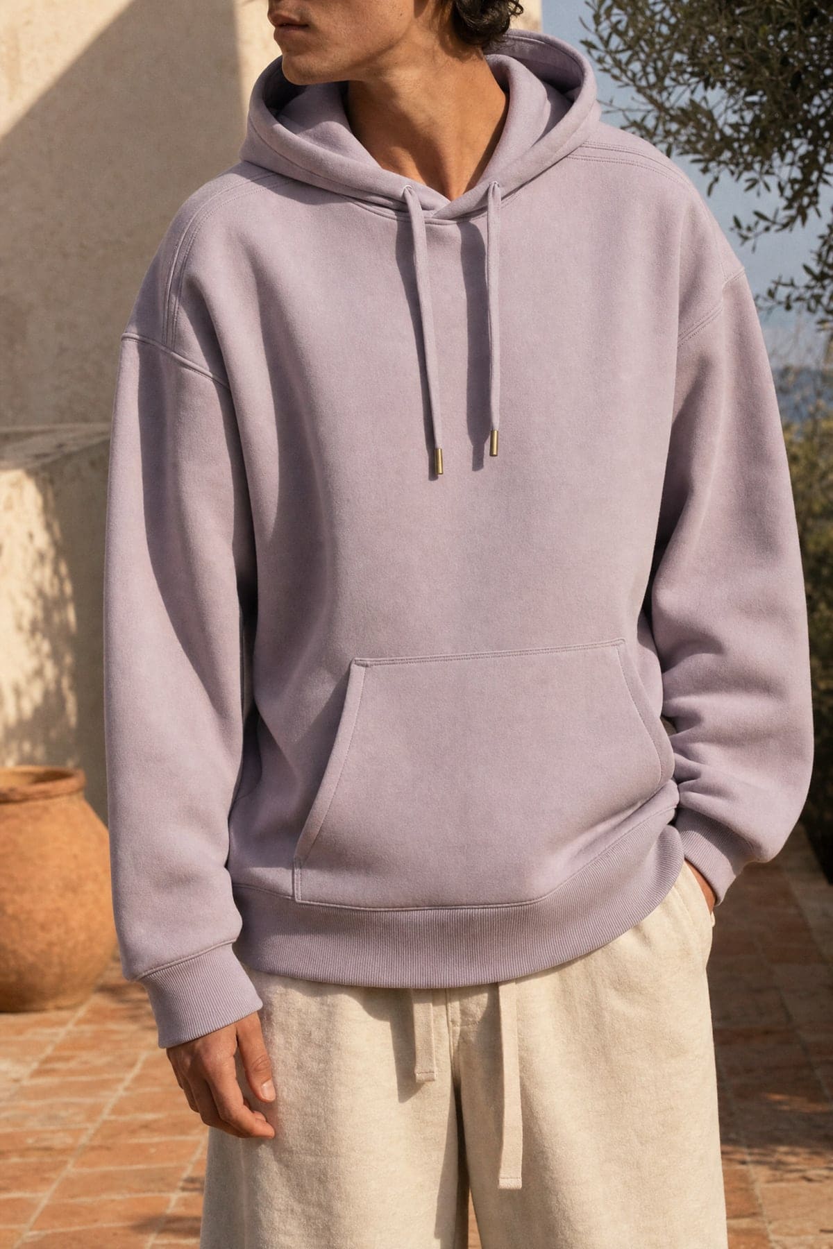 Hoodie in lilac, worn outdoors in warm afternoon light