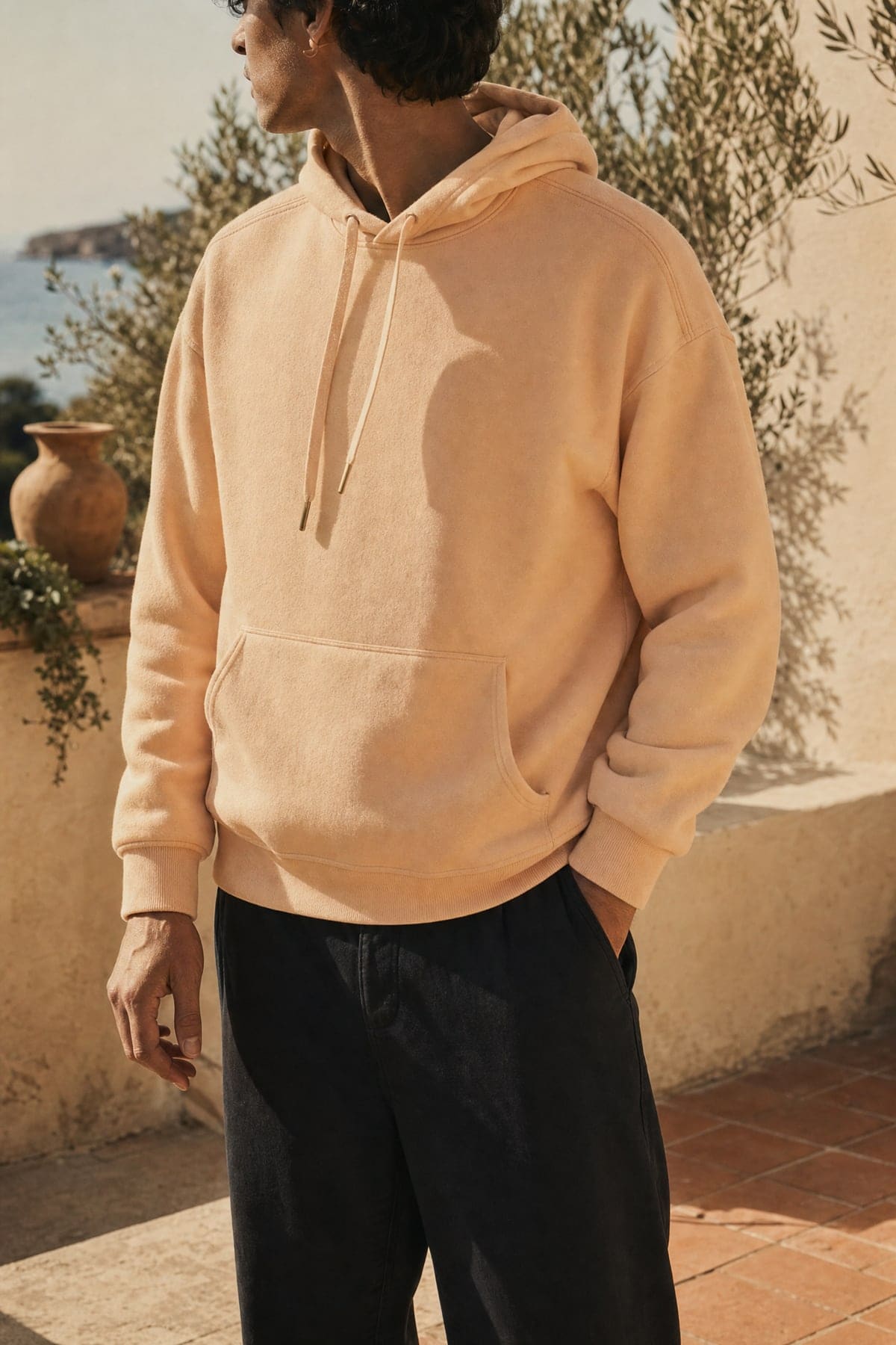 Hoodie in peach, worn outdoors in warm afternoon light