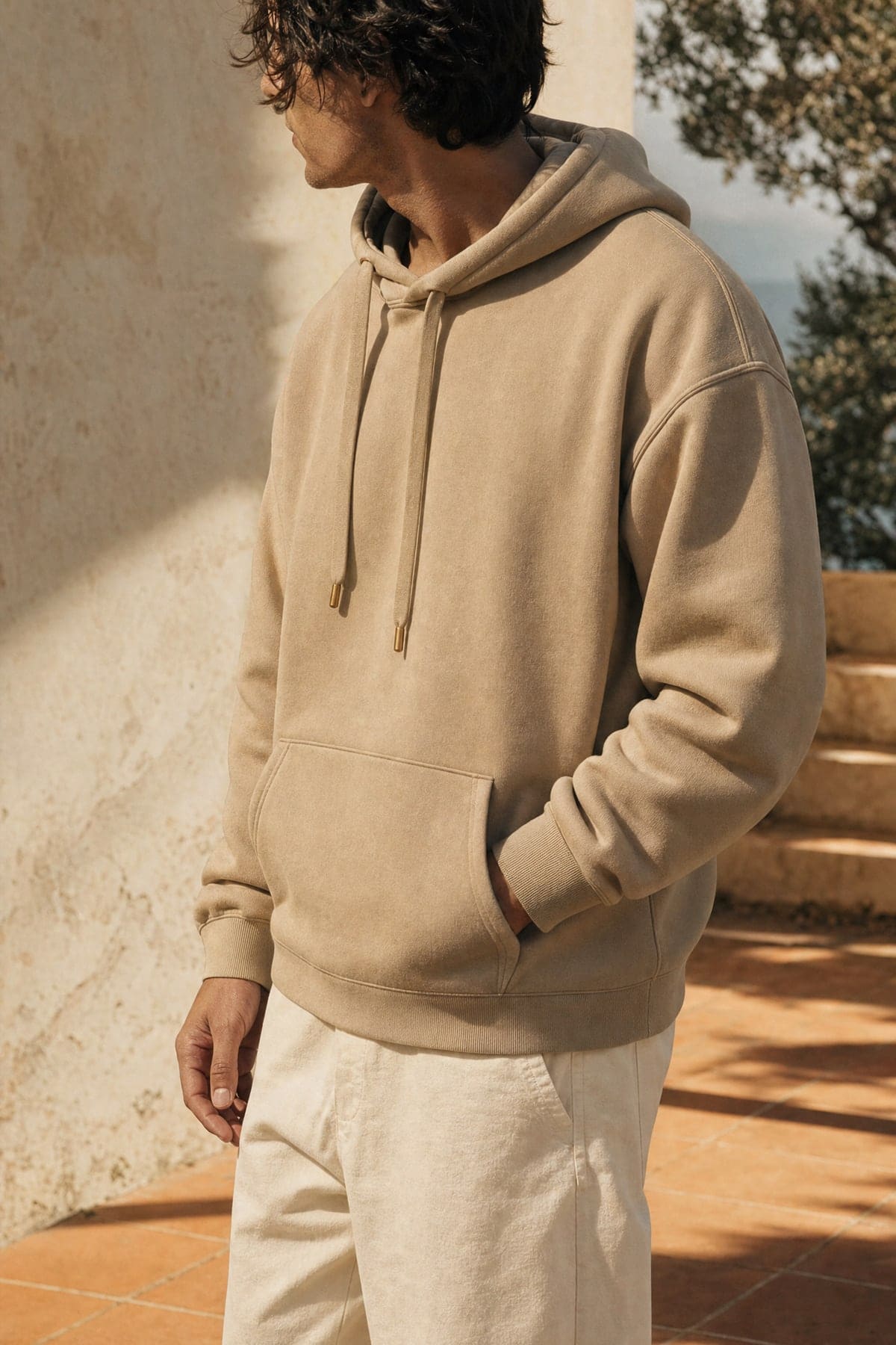 Hoodie in stone, worn outdoors in warm afternoon light