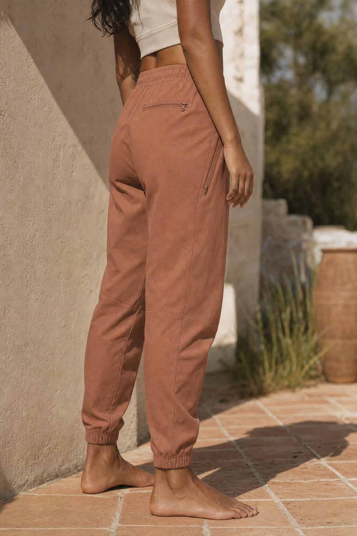 Joggers in clay, worn outdoors in warm afternoon light