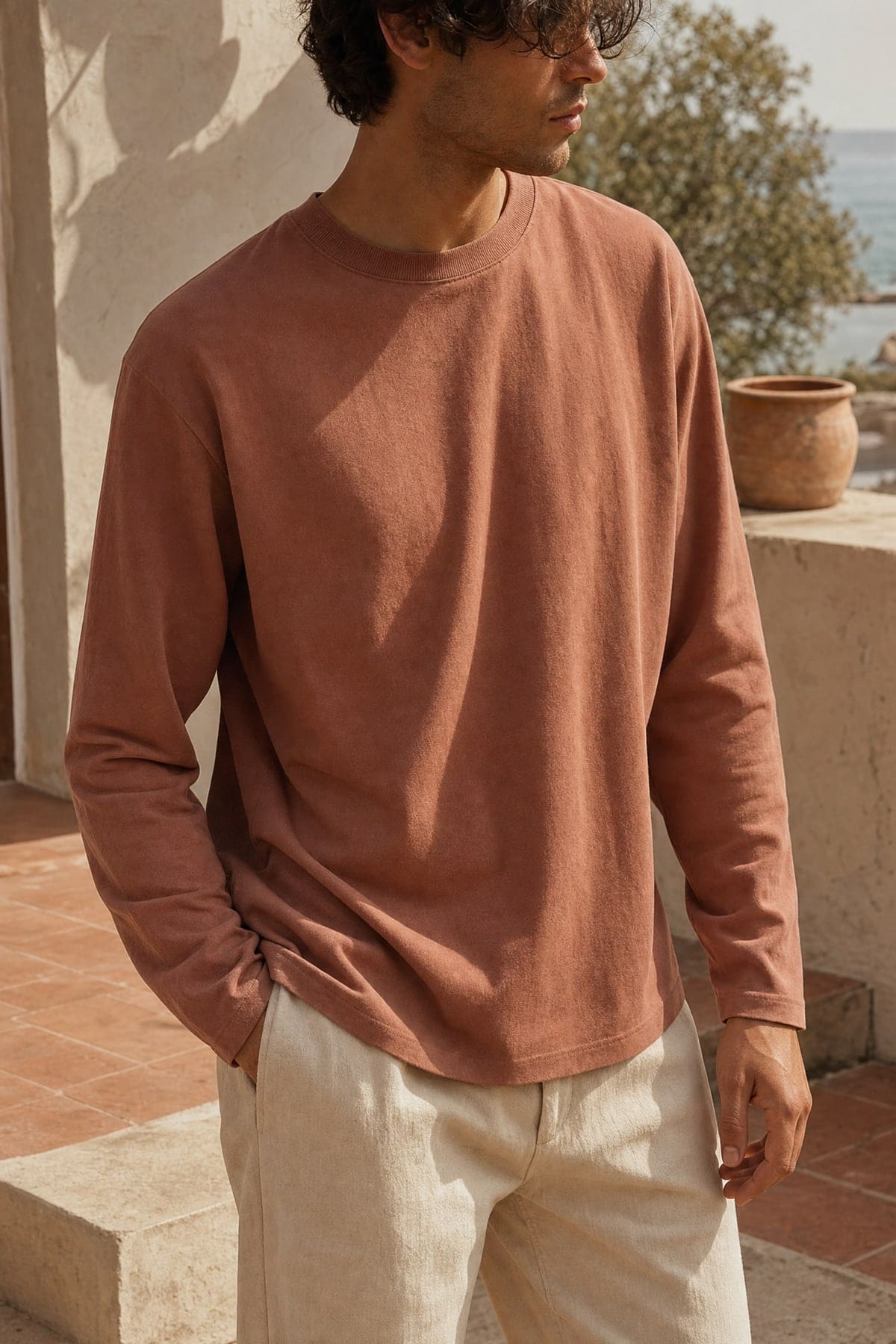 Long-sleeve in clay, worn outdoors in warm afternoon light