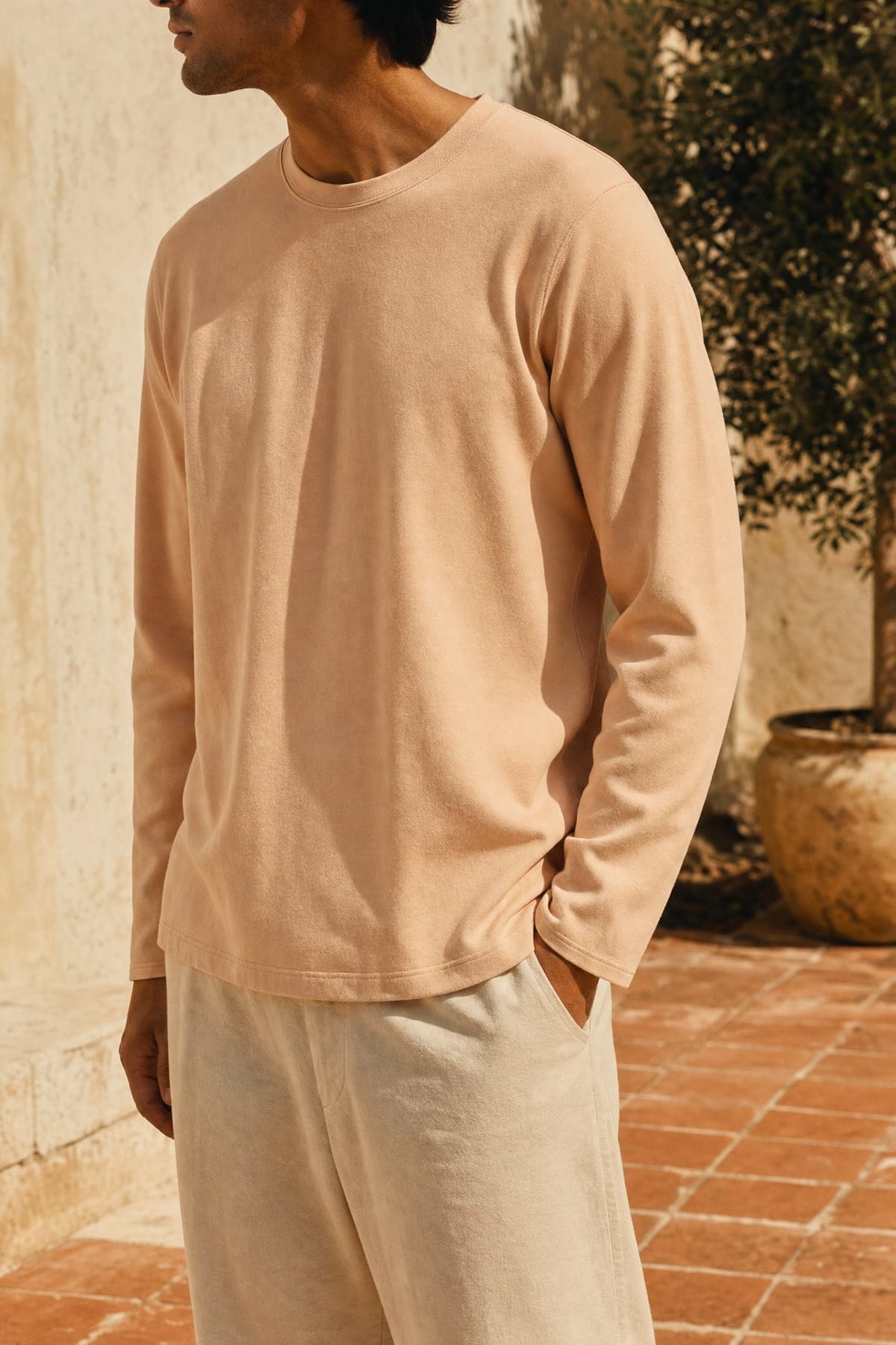 Long-sleeve in peach, worn outdoors in warm afternoon light