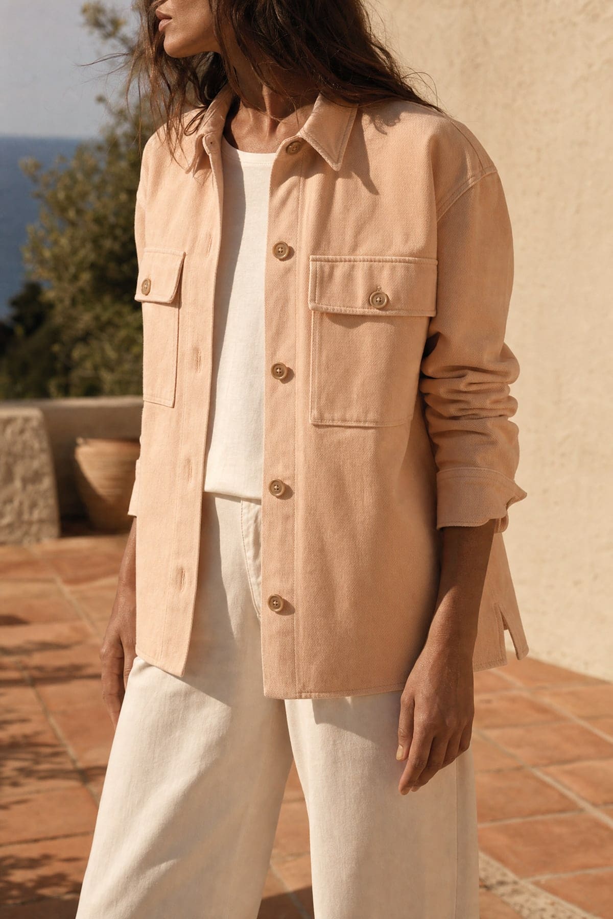 Overshirt in peach, worn outdoors in warm afternoon light