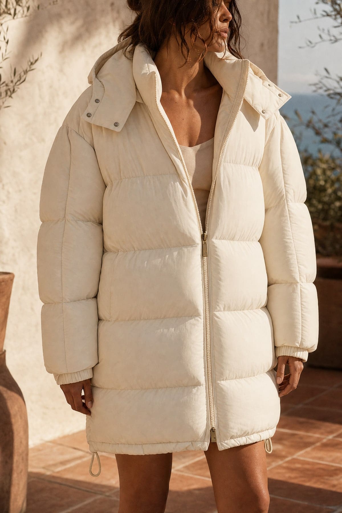 Puffer in ecru, worn outdoors in warm afternoon light