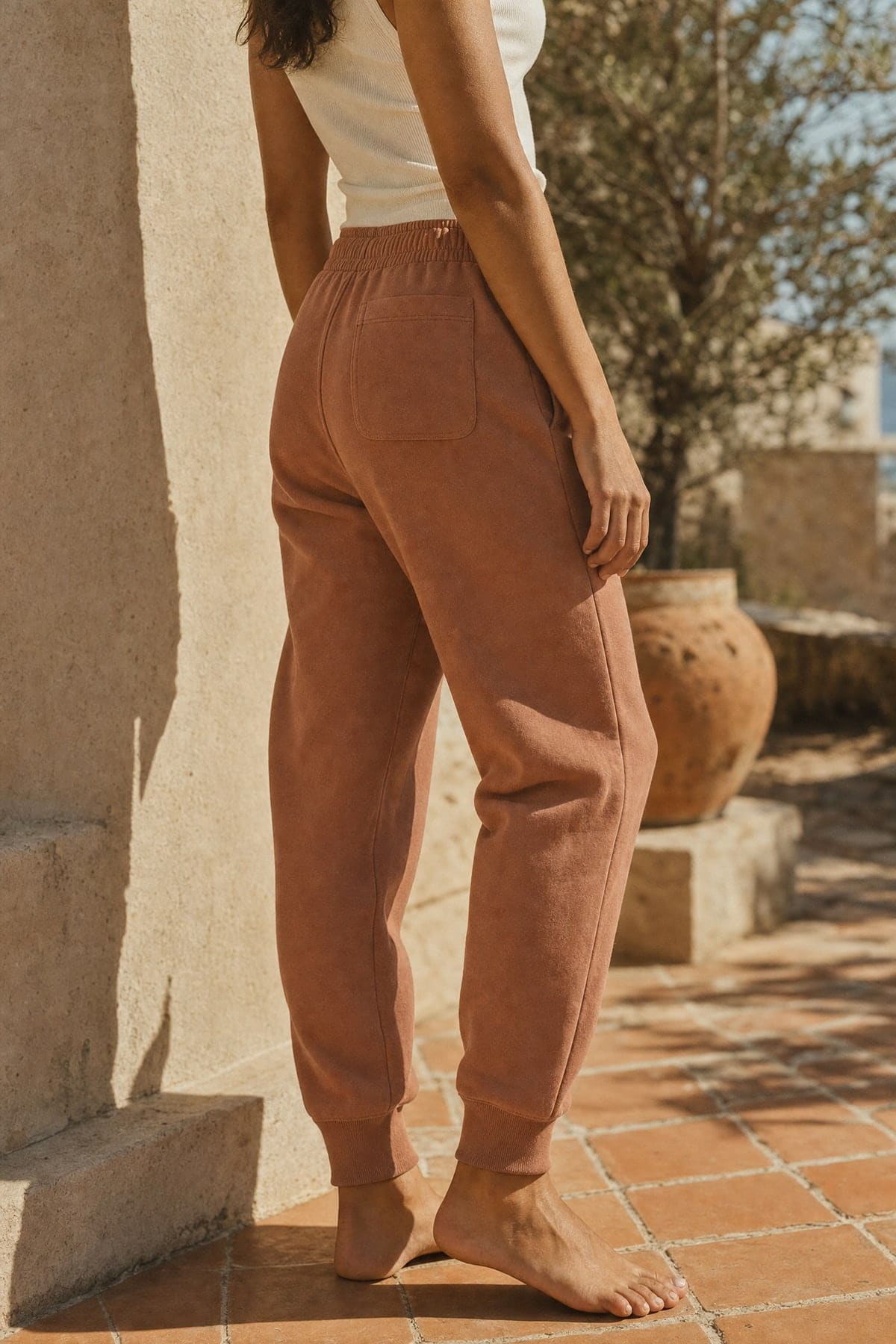 Sweats in clay, worn outdoors in warm afternoon light