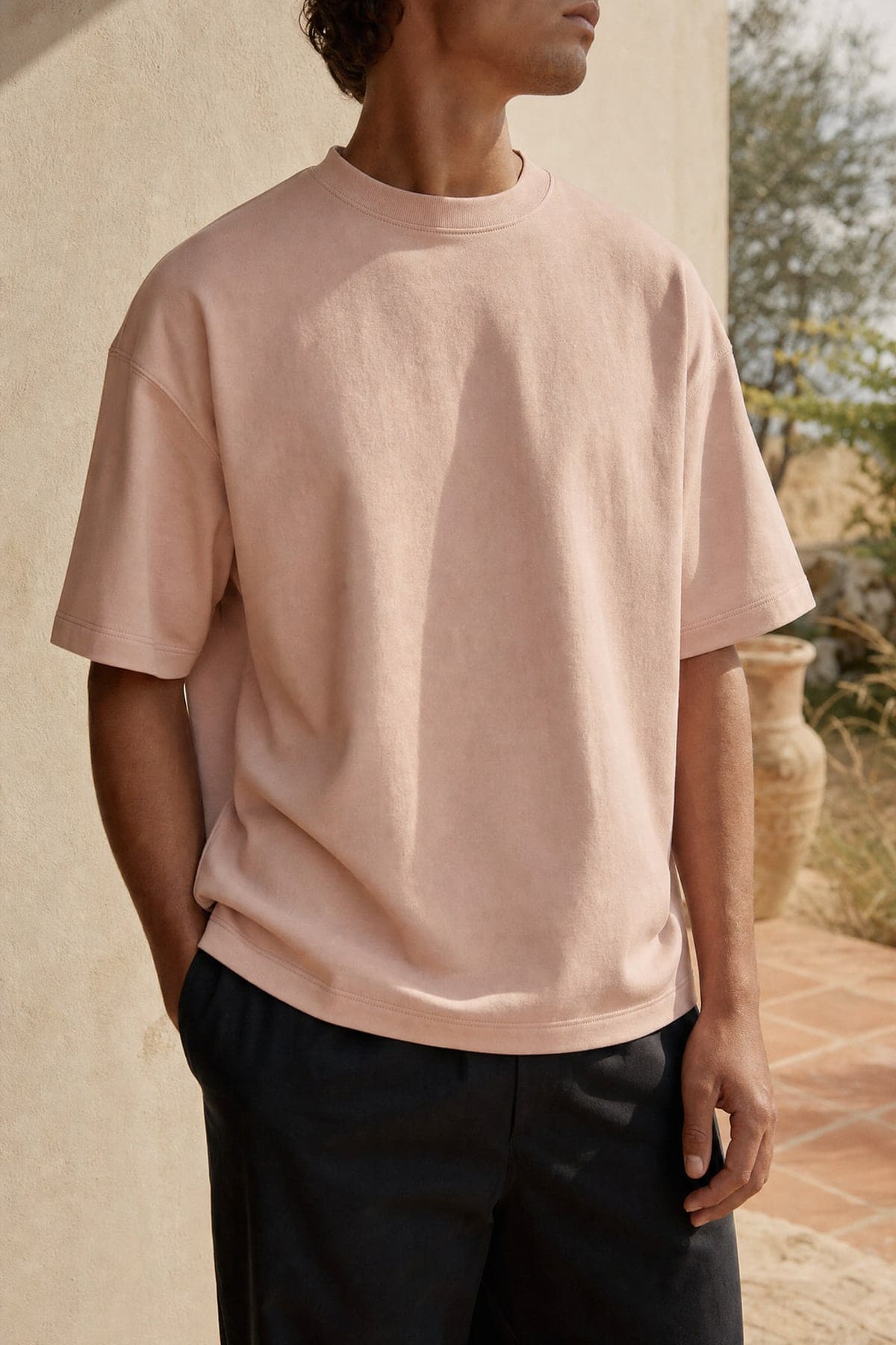 Tee in blush, worn outdoors in warm afternoon light