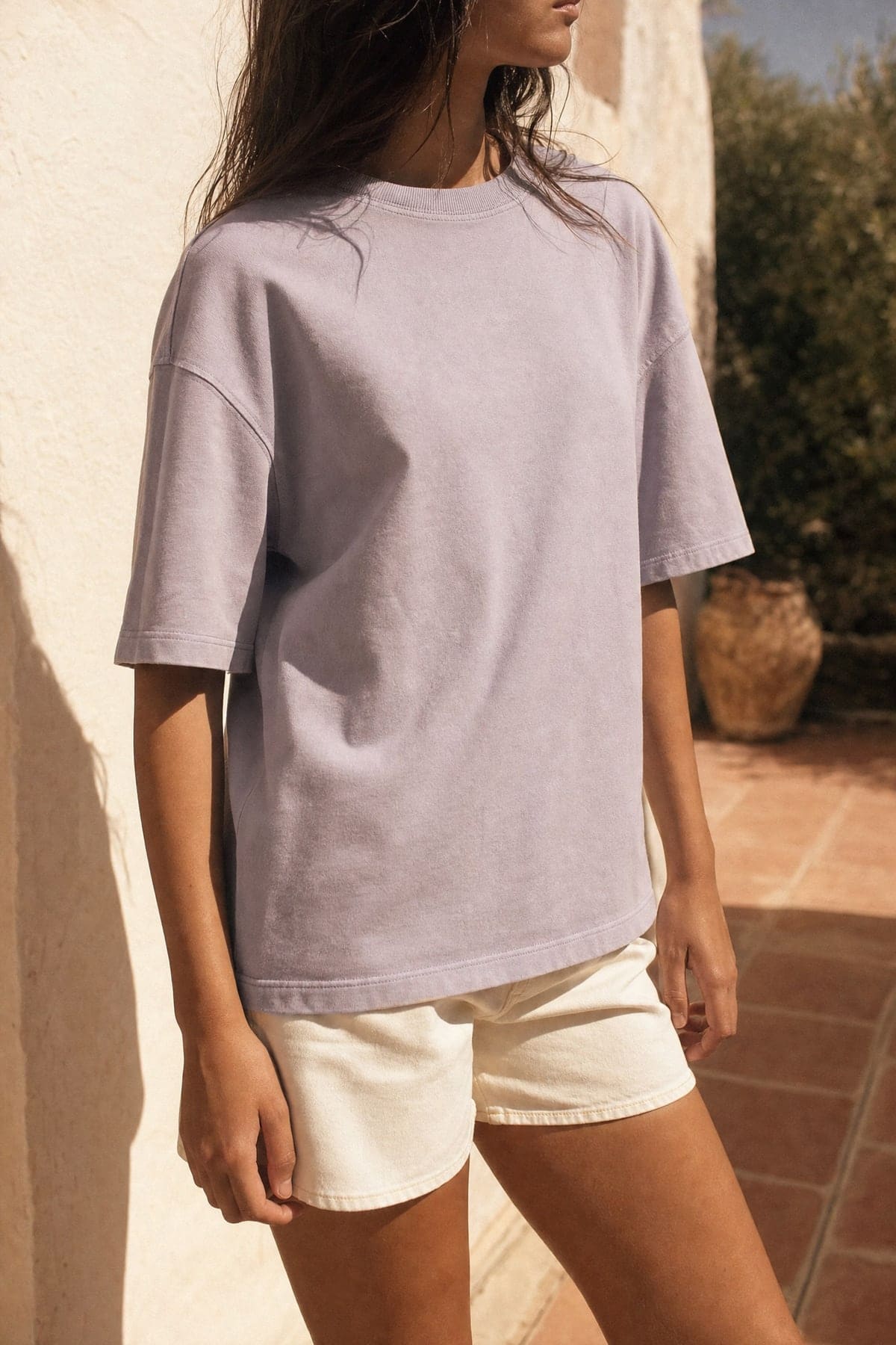 Tee in lilac, worn outdoors in warm afternoon light