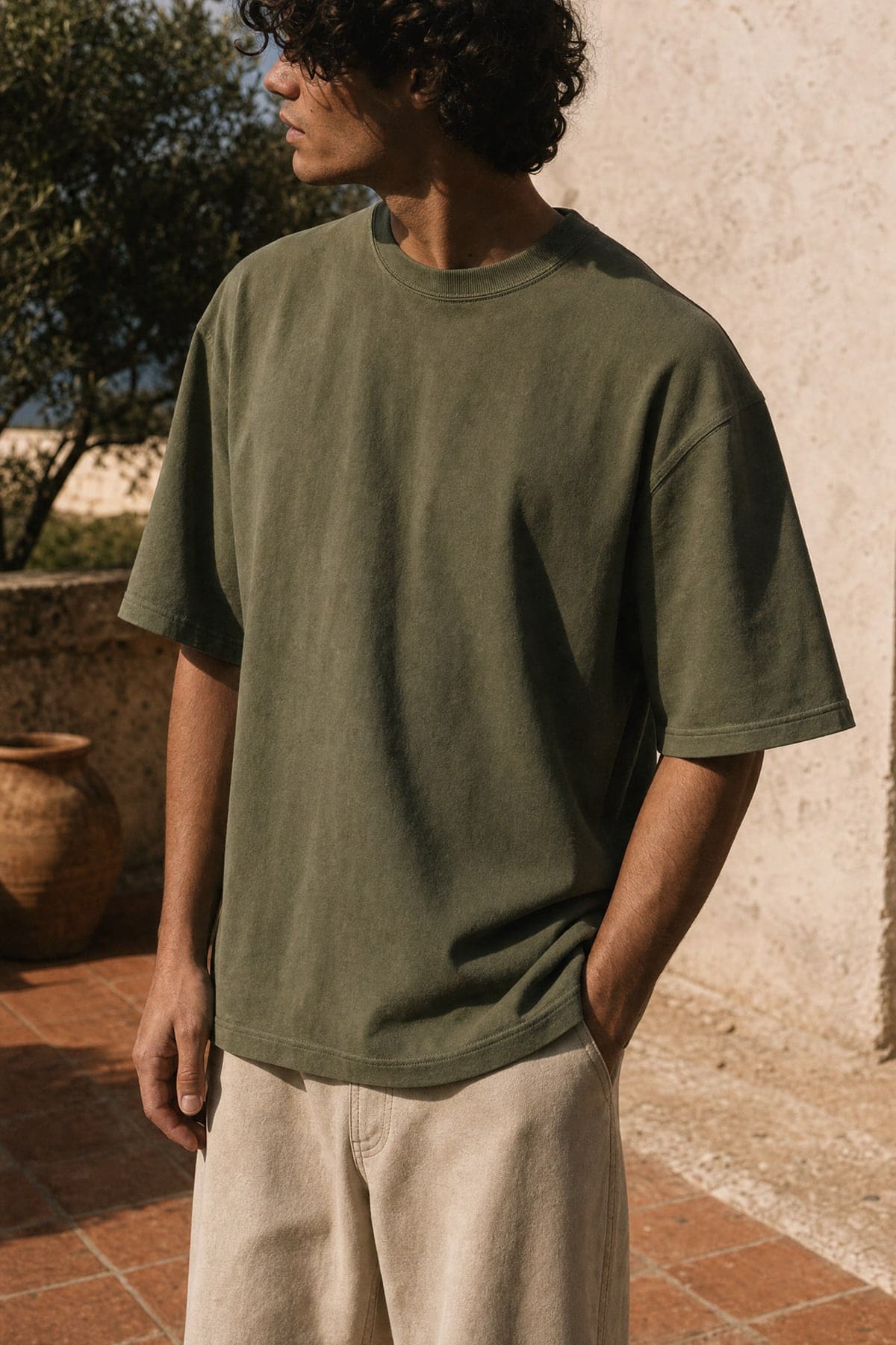 Tee in olive, worn outdoors in warm afternoon light