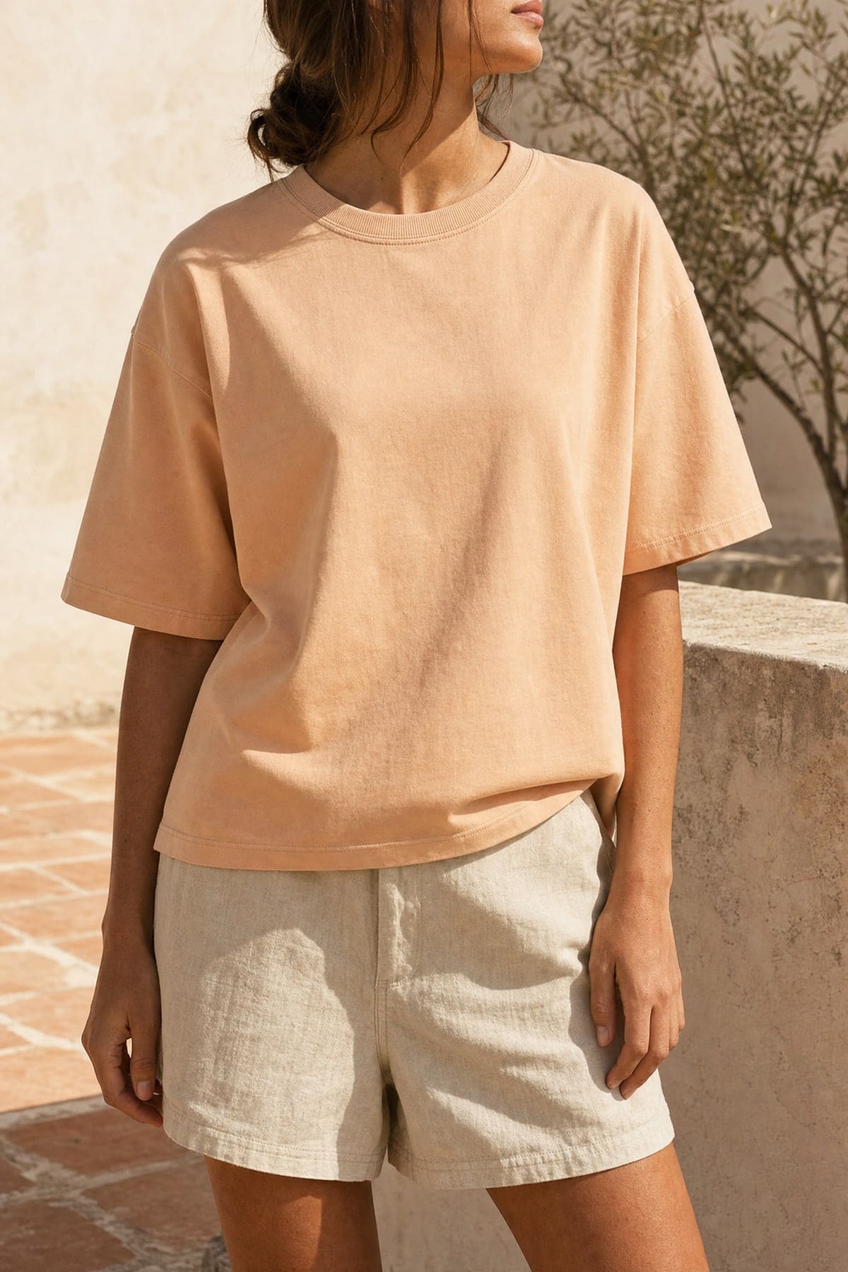 Tee in peach, worn outdoors in warm afternoon light
