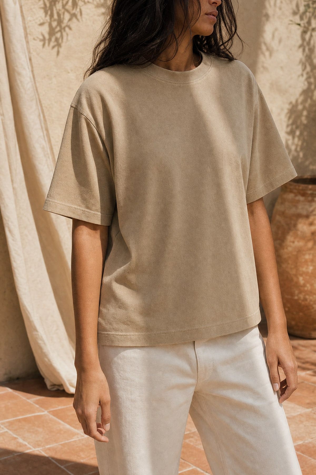 Tee in stone, worn outdoors in warm afternoon light